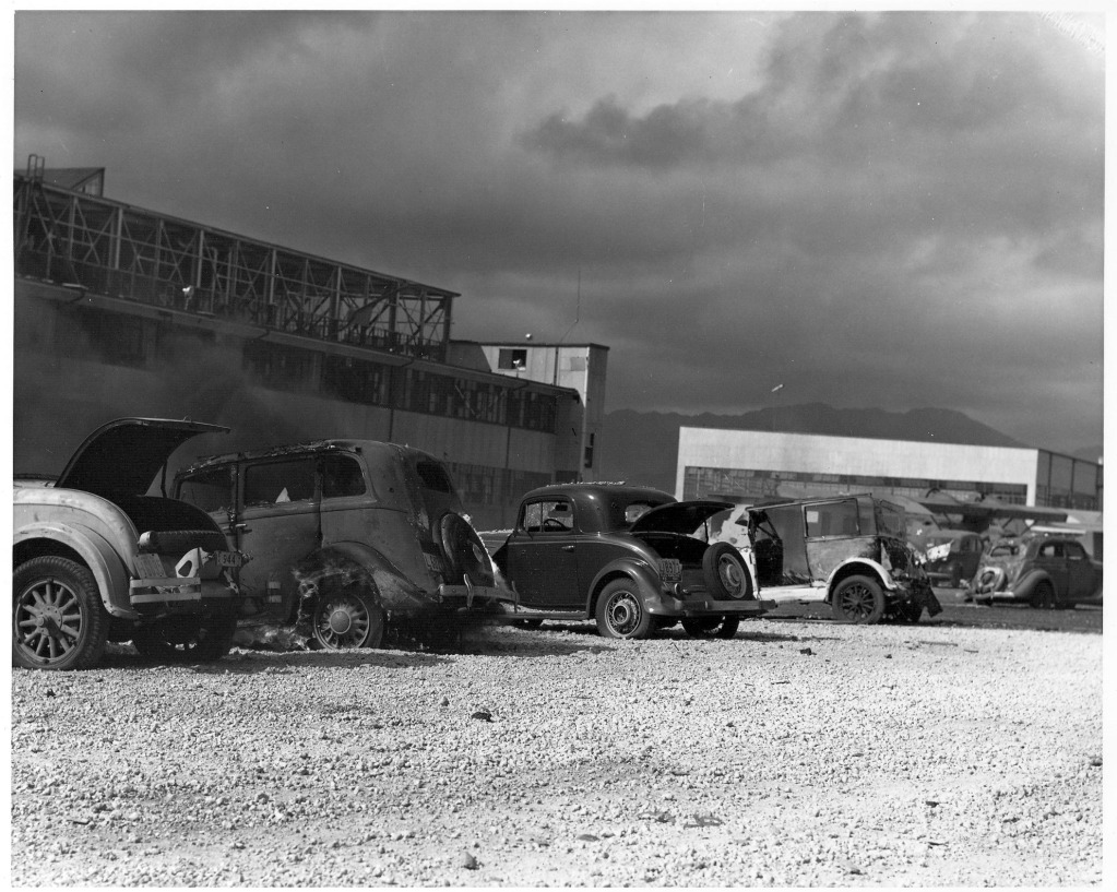 1936 Willys Sedan Model 77 burning after being strafed by Japanese aircraft